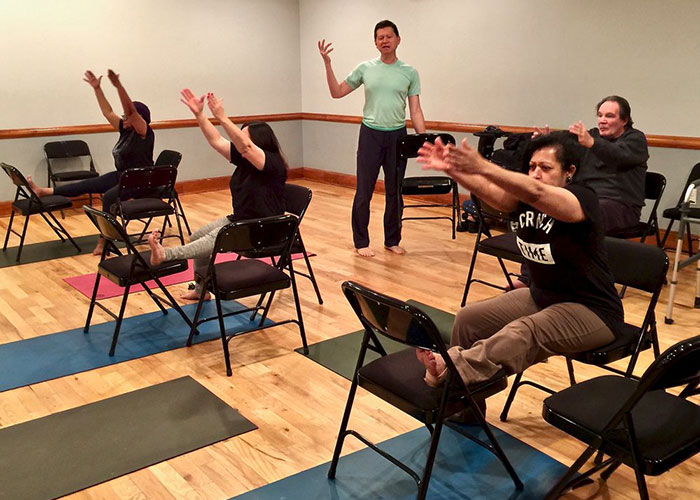 Photo of a group of people participating together in a physical class. Photo of a group of people participating together in a physical class.